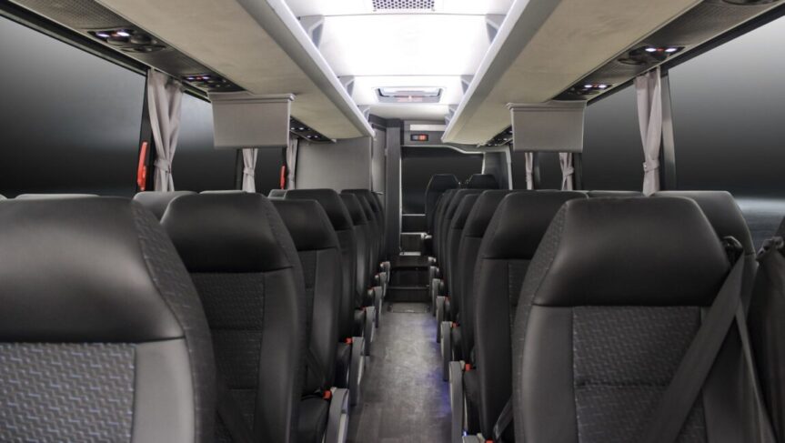 Interior image of Golden Limo Mini Charter Bus, with black leather seats, overhead lighting and wood panel floors.
