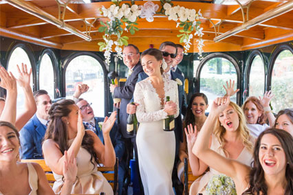 A Wedding party celebrating while riding on the Trolley.