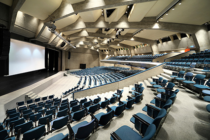 A large conference room with blue chairs.
