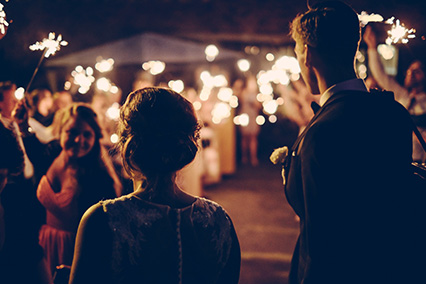 Couple entering an evening formal event with sparklers.