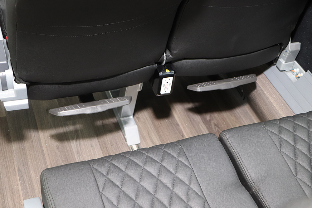 Interior image of Golden Limo Charter Bus foot rests behind seats