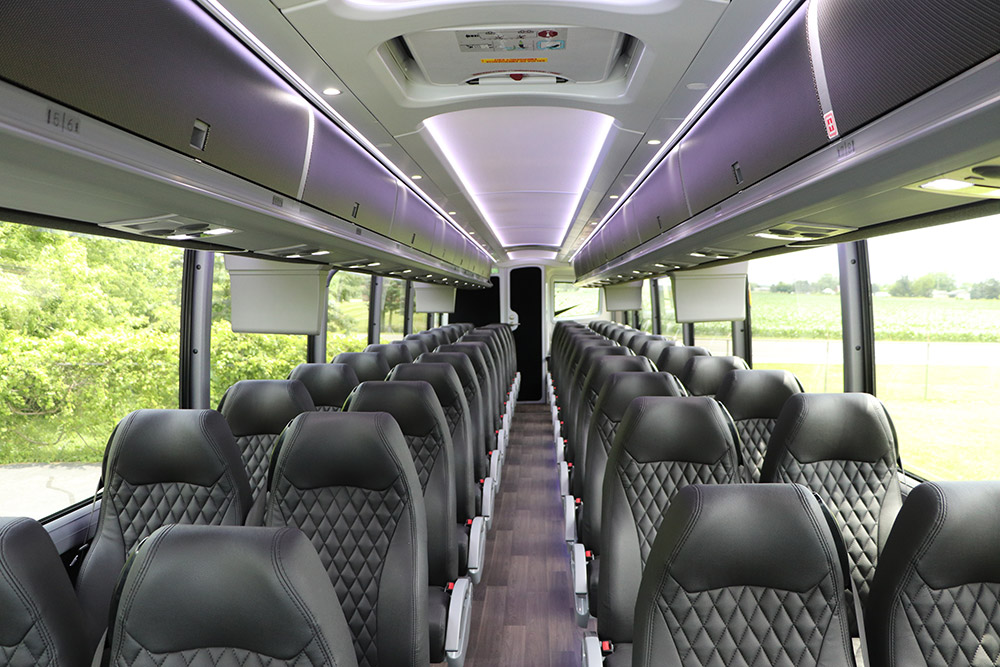 Interior image of Golden Limo Charter Bus with black leather seats, overhead lighting and wood panel floors
