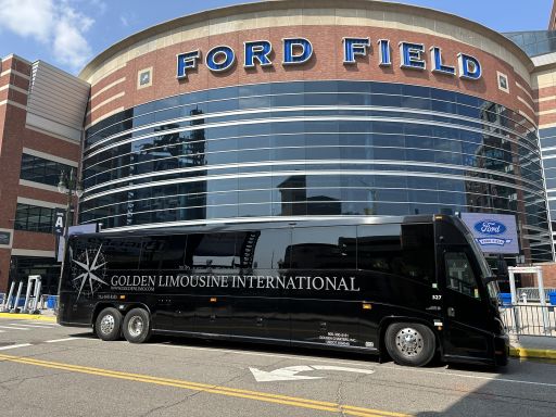 Golden Limo Charter Bus parked outside entrance to Ford Field in Detroit Michigan