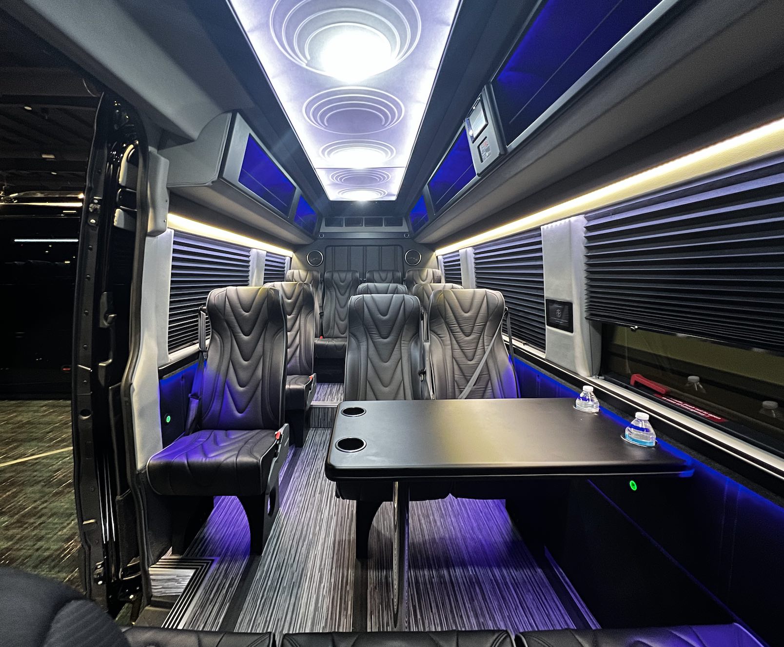 Golden Limo Executive Sprinter Shuttle, interior view with view of conference table seating and rows of individual seating
