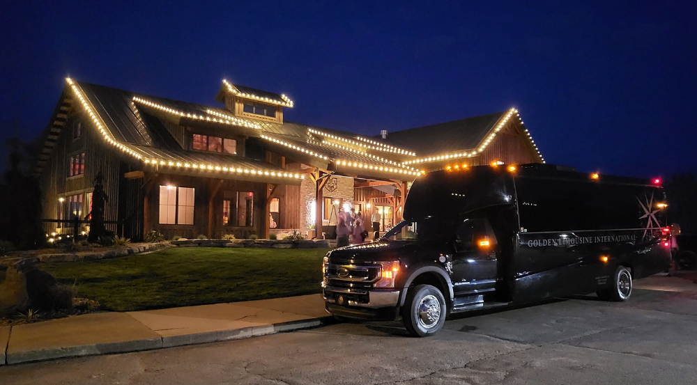 Golden Limo Executive Coach parked outside a venue destination at night waiting for riders to board.