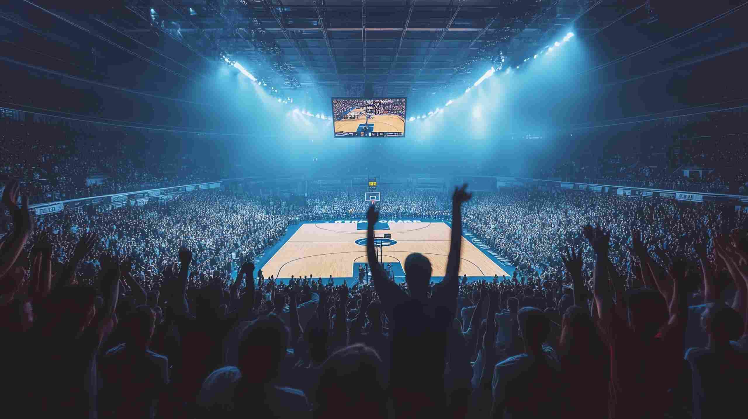 Crowd of basketball fans cheering inside a packed indoor arena during a live game with bright lights illuminating the court.