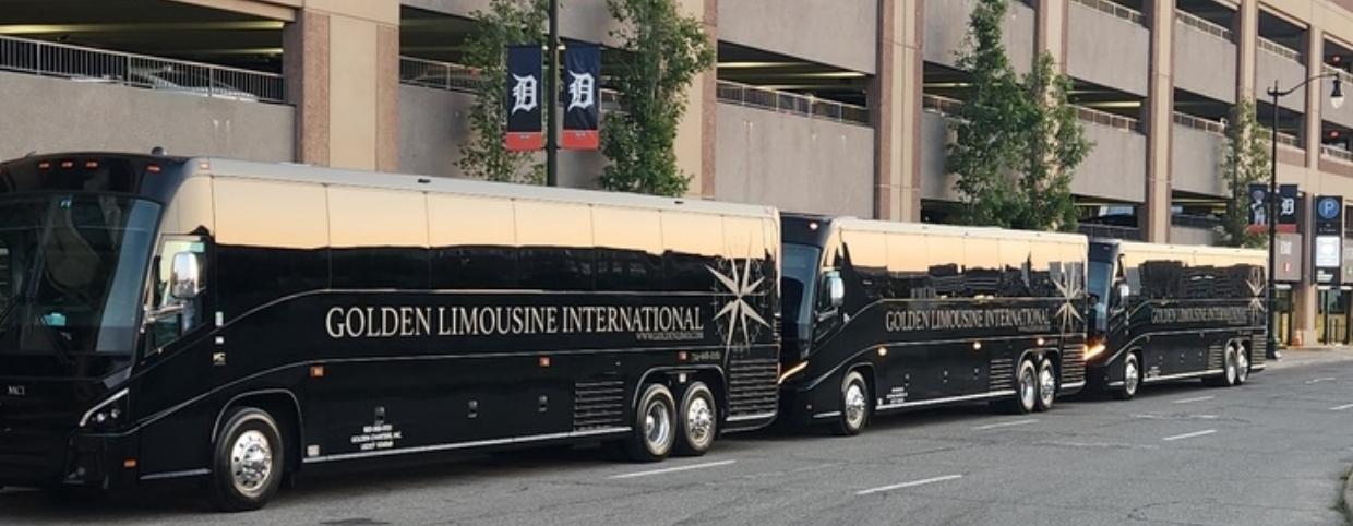 Three black luxury motor coaches from Golden Limousine International parked along a city street, showcasing the company's premium charter bus fleet for corporate, airport, sports, and group transportation services.