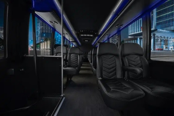 Luxury shuttle bus interior with leather seats, LED lighting, and spacious seating by Golden Limousine International.